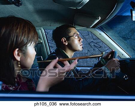 Couple in a car, woman smoking while man driving View Large Photo Image Stock Photograph - Couple in a car, woman smoking while man driving. Fotosearch