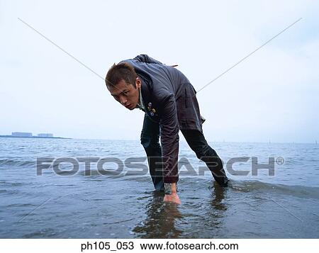 Stock Image - Injured man at the beach. Fotosearch