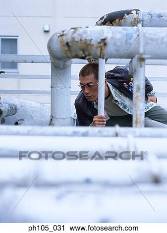 Man hiding under huge pipes View Large Photo Image Stock Image - Man hiding under huge pipes. Fotosearch