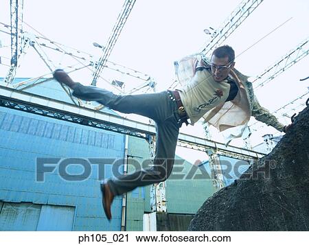 Man jumping over a wall of rocks View Large Photo Image Stock Image - Man jumping over a wall of rocks. Fotosearch