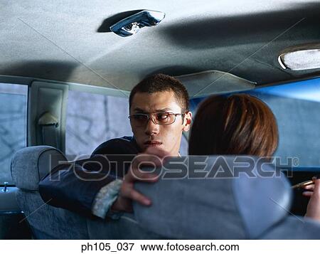 Stock Photo - Man looking over his shoulder in a car. Fotosearch