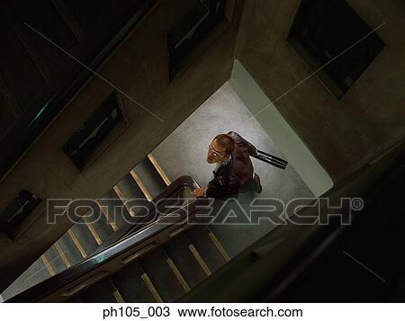 Man looking up at railings of stairwell View Large Photo Image Stock Image - Man looking up at railings of stairwell. Fotosearch