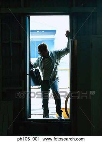 Man standing at door, holding a briefcase View Large Photo Image Stock Image - Man standing at door, holding a briefcase. Fotosearch