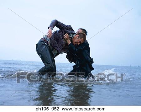 Two men fighting at the beach View Large Photo Image Stock Image - Two men fighting at the beach. Fotosearch