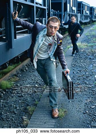 Two men in a chase along railway track View Large Photo Image Stock Image - Two men in a chase along railway track. Fotosearch