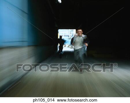 Picture - Two men in a chase, blur motion. Fotosearch