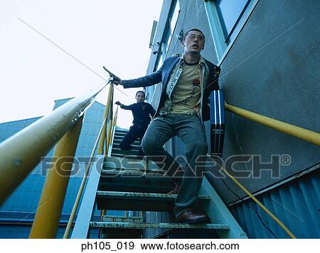 Two men running down staircase View Large Photo Image Stock Photo - Two men running down staircase . Fotosearch