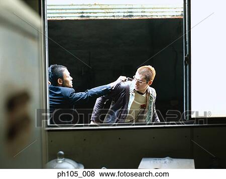 Stock Photo - Two men struggling at the window, view of inside. Fotosearch