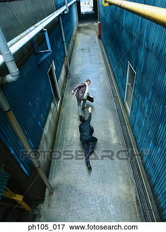 Stock Photo - Two men struggling in a small alley, high angle view. Fotosearch