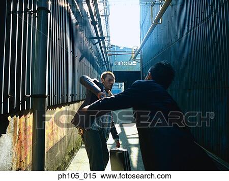 Two men struggling in a small alley View Large Photo Image Stock Photography - Two men struggling in a small alley. Fotosearch