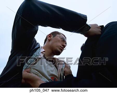 Two men struggling, low angle view View Large Photo Image Stock Photo - Two men struggling, low angle view. Fotosearch