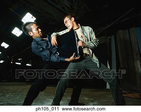 Stock Image - Two men struggling over a briefcase. Fotosearch