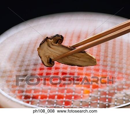 Stock Photo - Chopsticks holding sliced mushroom. Fotosearch
