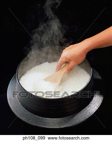 Scooping rice from rice cooker View Large Photo Image Stock Photo - Scooping rice from rice cooker. Fotosearch