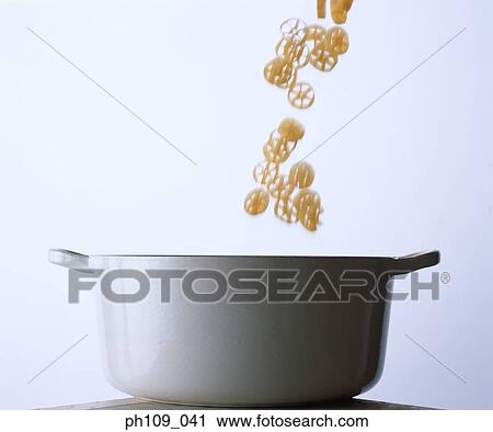 Stock Image - Dropping slices of lotus roots into a pot. Fotosearch
