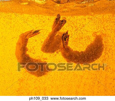 Stock Image - Prawns in boiling oil. Fotosearch
