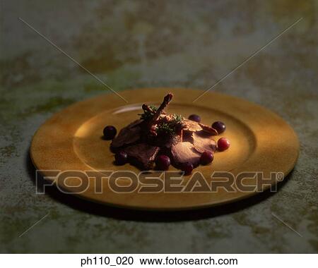 Stock Image - Roasted meat slices with berries. Fotosearch