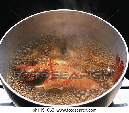 Stock Image - Boiling fish in pot. Fotosearch
