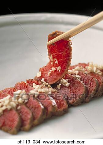 Chopsticks picking a slice of beef View Large Photo Image Picture - Chopsticks picking a slice of beef. Fotosearch