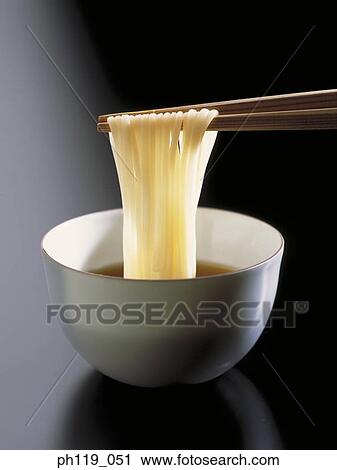 Stock Image - Chopsticks picking noodles from bowl. Fotosearch