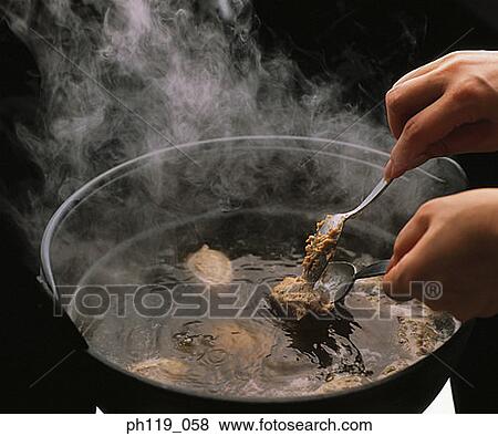 Putting meat balls in hot soup with spoons View Large Photo Image Stock Photo - Putting meat balls in hot soup with spoons. Fotosearch