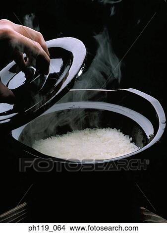 Removing cover of rice cooker, cooked rice inside View Large Photo Image Picture - Removing cover of rice cooker, cooked rice inside. Fotosearch