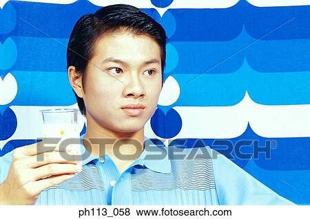 Man holding a glass of milk View Large Photo Image Stock Photo - Man holding a glass of milk. Fotosearch