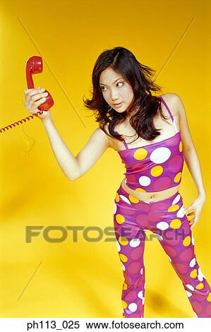 Stock Photography - Woman gives an agitated look at the handset. Fotosearch