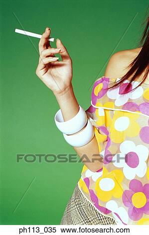 Young woman in floral blouse, holding a cigarette View Large Photo Image Stock Photography - Young woman in floral blouse, holding a cigarette. Fotosearch