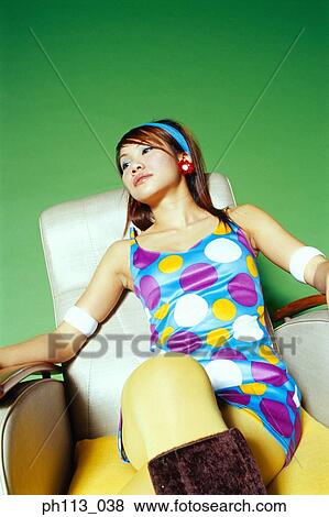 Young woman in polka dot blouse, resting on couch View Large Photo Image Stock Photo - Young woman in polka dot blouse, resting on couch. Fotosearch