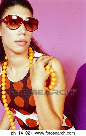 Stock Photo - Portrait of a young woman wearing sunglass. Fotosearch