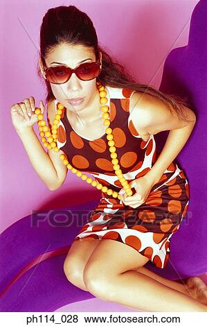 Stock Photo - Portrait of a young woman wearing sunglass. Fotosearch