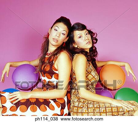Two woman sitting on a colorful sofa View Large Photo Image Stock Photo - Two woman sitting on a colorful sofa. Fotosearch