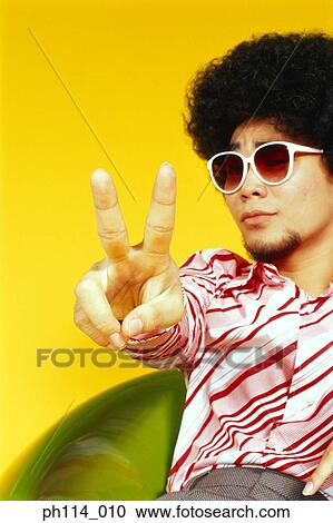 Young Asian male with afro hair in sitting with victory pose View Large Photo Image Stock Image - Young Asian male with afro hair in sitting with victory pose. Fotosearch