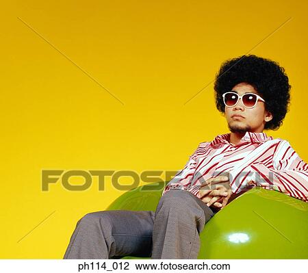 Young Asian male with afro hair in sitting on ball chair View Large Photo Image Stock Image - Young Asian male with afro hair in sitting on ball chair. Fotosearch