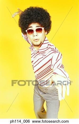 Stock Photograph - Young Asian male with afro hair in dancing pose. Fotosearch