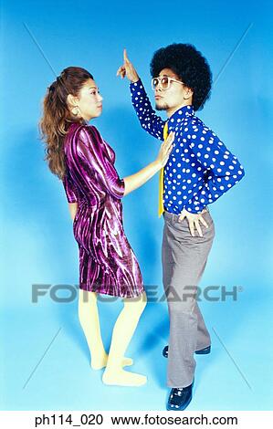 Stock Image - Young woman dancing with man with afro hair. Fotosearch