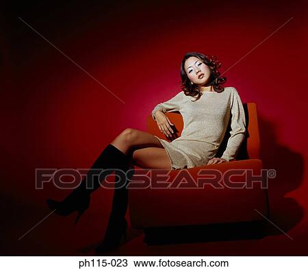 Portrait of a young woman sitting on red couch View Large Photo Image Stock Image - Portrait of a young woman sitting on red couch. Fotosearch