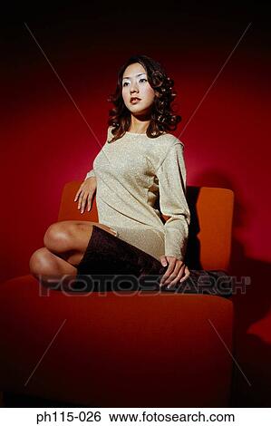 Portrait of a young woman sitting on red couch View Large Photo Image Stock Photograph - Portrait of a young woman sitting on red couch. Fotosearch