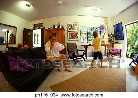 Father blowing balloons, son playing View Large Photo Image Picture - Father blowing balloons, son playing. Fotosearch