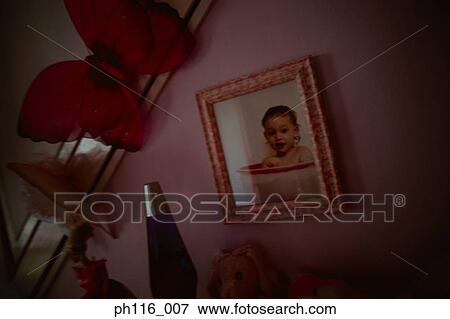 Photo frame of a baby on wall View Large Photo Image Stock Photo - Photo frame of a baby on wall. Fotosearch