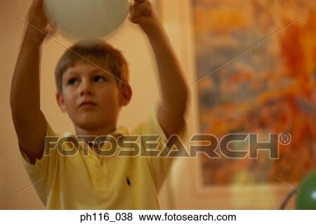 Young boy holding a balloon View Large Photo Image Stock Photo - Young boy holding a balloon. Fotosearch