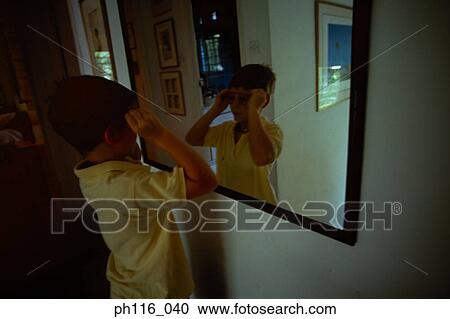Young boy putting on sunglass in front of mirror View Large Photo Image Stock Image - Young boy putting on sunglass in front of mirror. Fotosearch
