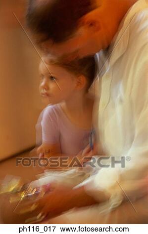 Stock Photo - Young daughter sitting by Father. Fotosearch