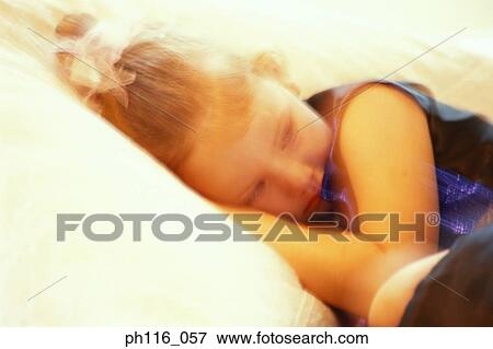 Young girl lying on bed, sulking View Large Photo Image Stock Photo - Young girl lying on bed, sulking. Fotosearch
