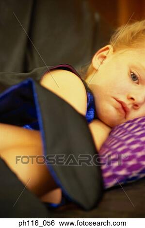 Young girl lying on sofa, sulking View Large Photo Image Stock Photograph - Young girl lying on sofa, sulking. Fotosearch
