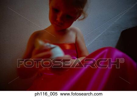 Stock Photography - Young girl on stairs in pink costume playing with toy. Fotosearch