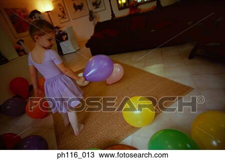 Stock Image - Young girl surrounded by balloons. Fotosearch