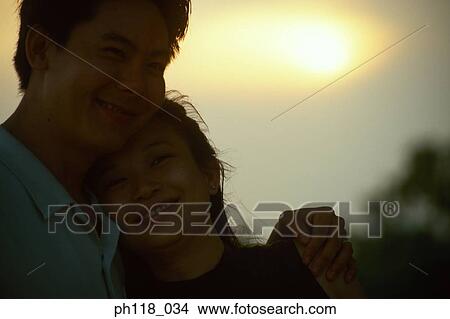 Couple outdoors, man with arm around woman's shoulder View Large Photo Image Picture - Couple outdoors, man with arm around woman's shoulder . Fotosearch