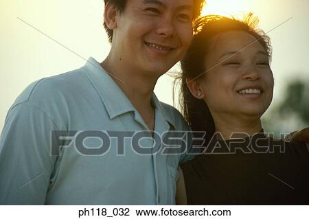 Couple outdoors, man with arm around woman's shoulder View Large Photo Image Stock Image - Couple outdoors, man with arm around woman's shoulder . Fotosearch